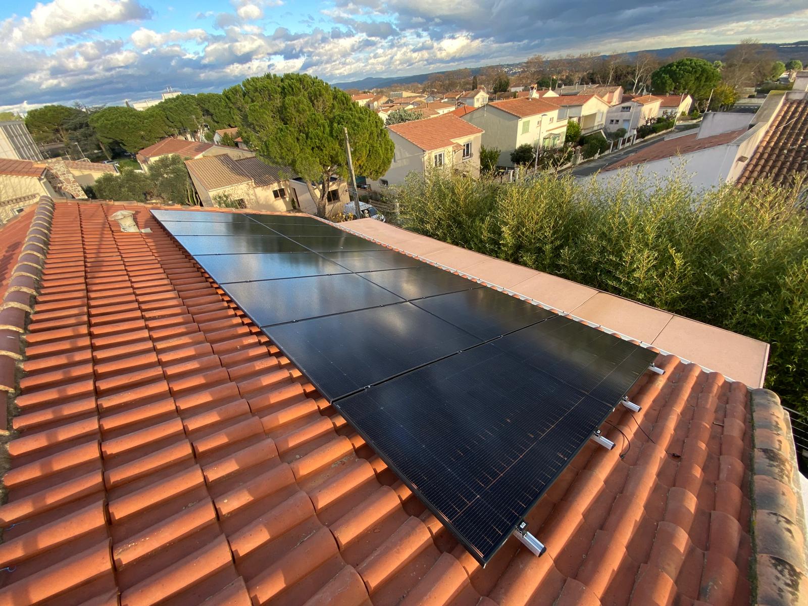 Rangées de panneaux photovoltaïques sur une toiture en tuiles rouges